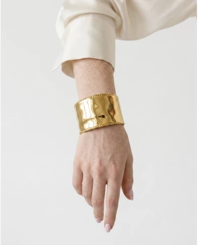 Brazalete Éclat — minimalismo dorado con textura sofisticada.