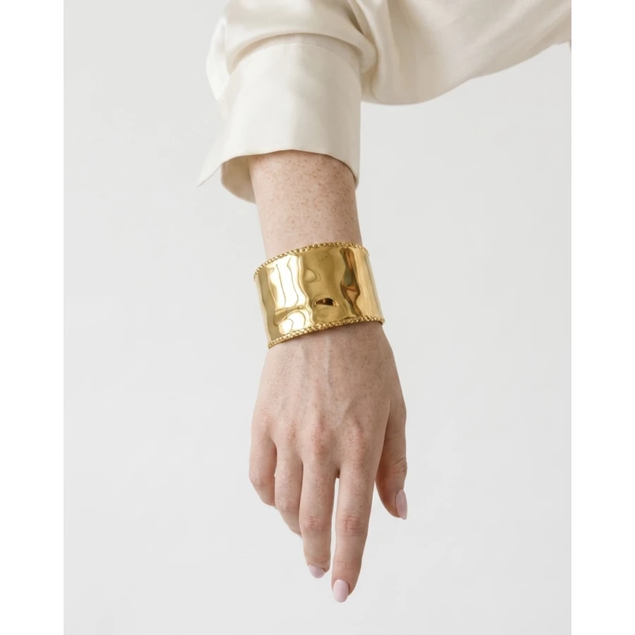 Brazalete Éclat — minimalismo dorado con textura sofisticada.