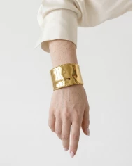 Brazalete Éclat — minimalismo dorado con textura sofisticada.